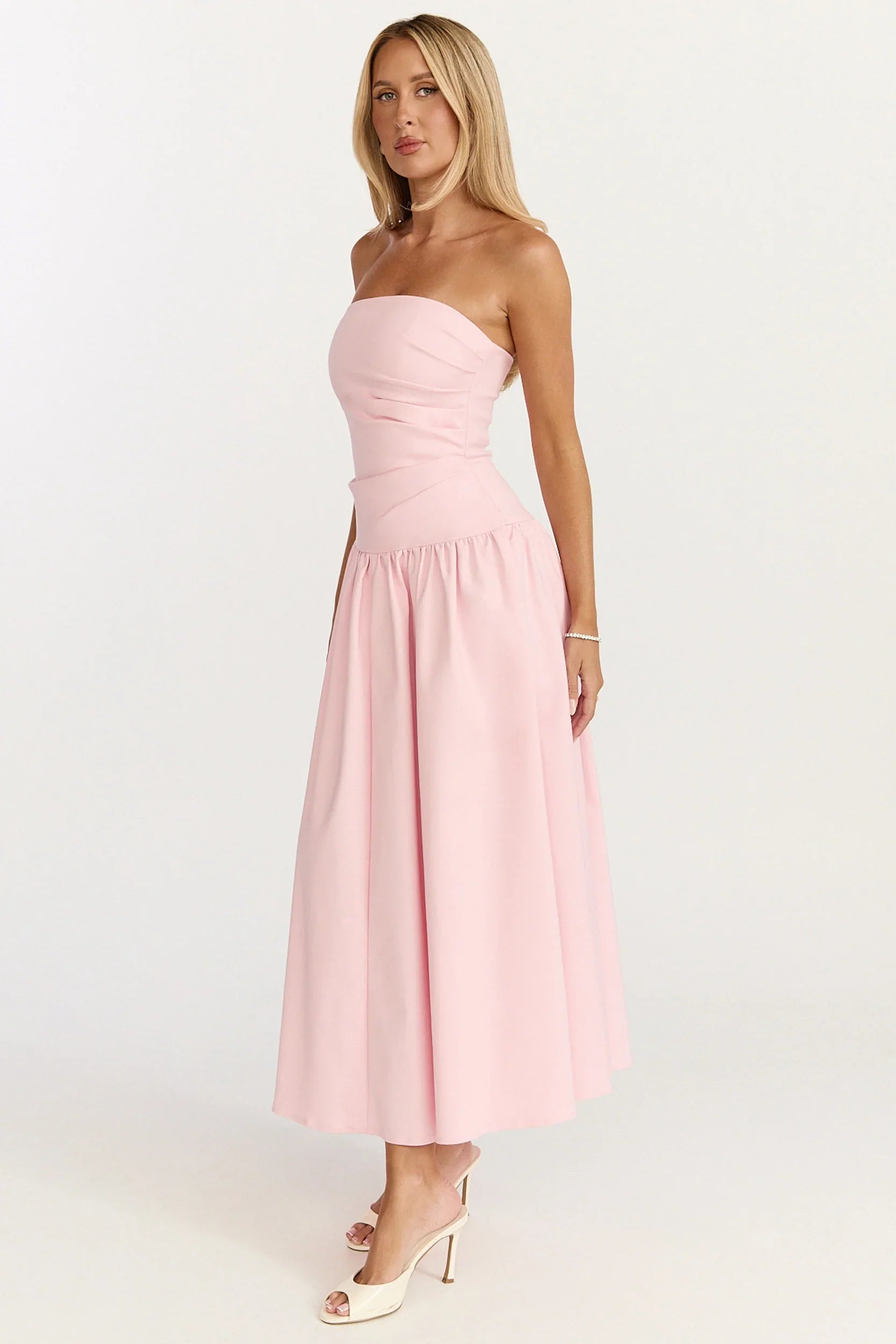 Robe longue Louisa – Robe évasée rose avec bustier, fronces latérales et taille basse.